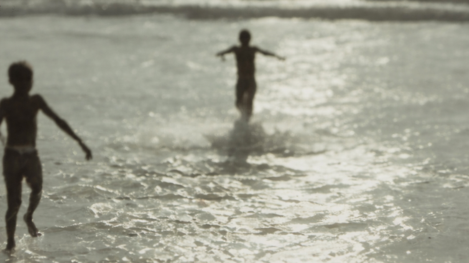 Film still of two black youths playing at the shore